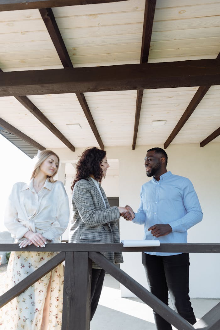 A diverse group of adults engaged in a business handshake outdoors, symbolizing teamwork and collaboration.